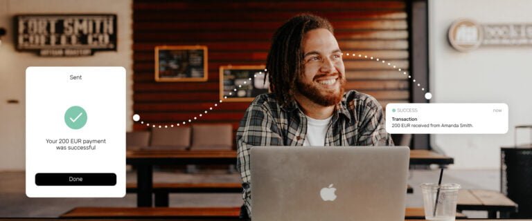 Man on a laptop with notification pop ups of a successful global payment