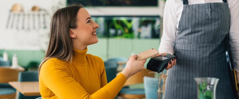 Woman paying in a coffee shop with her card