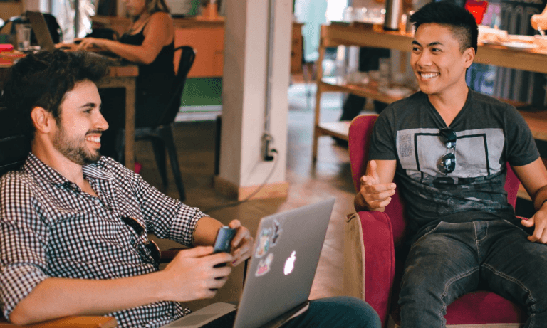 Two men in a cafe laughing together