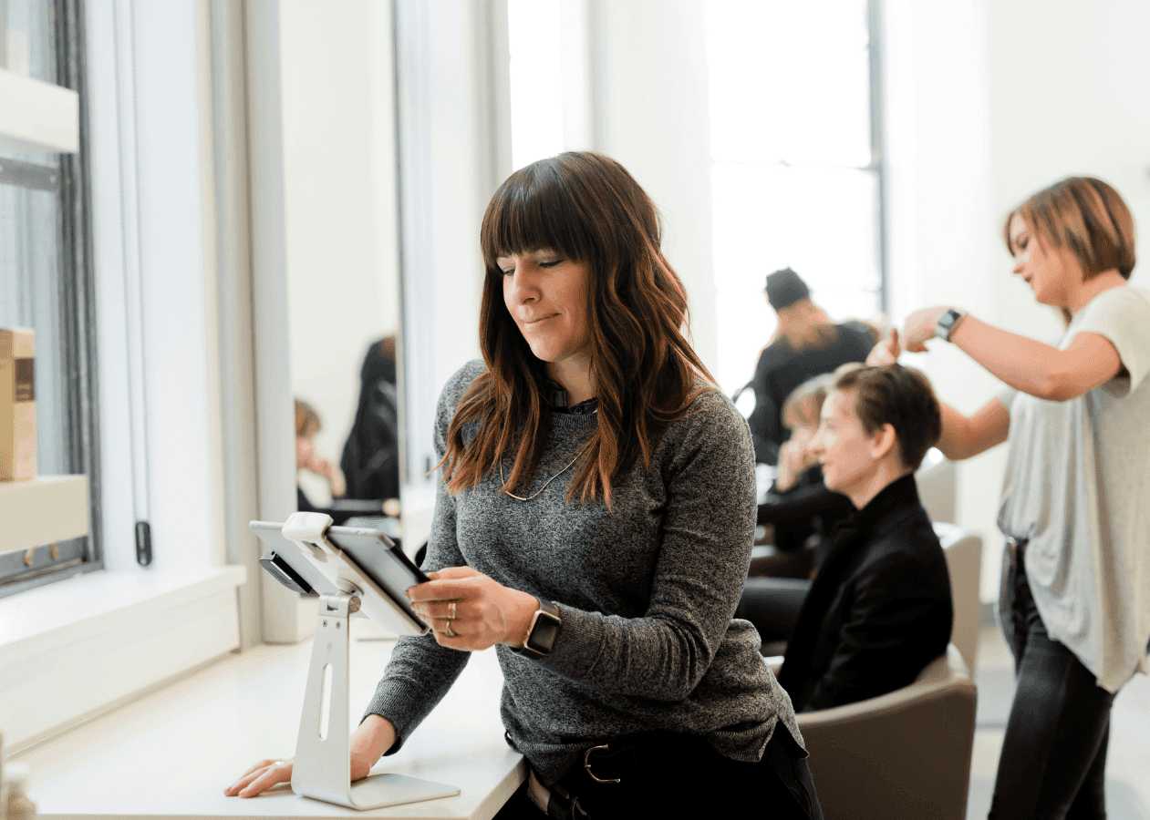 Woman at a hairdressers looking at an iPad