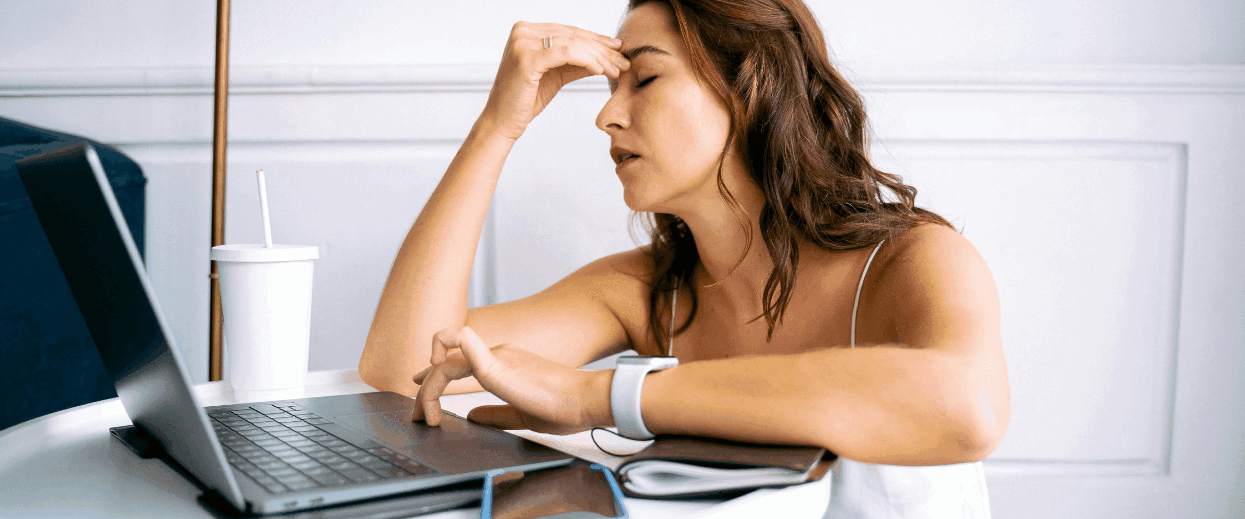 A woman looking frustrated as she works on her laptop