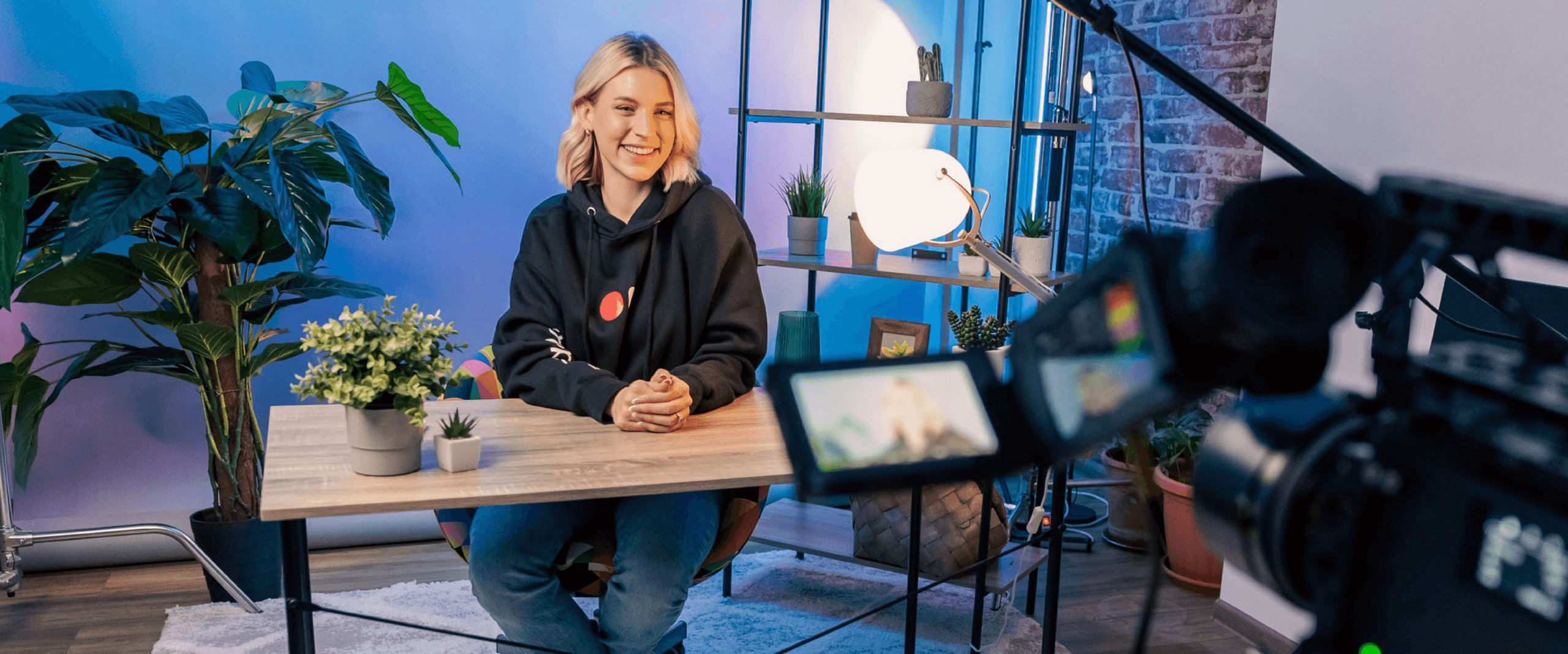 Lifestyle image of a content creator filming themselves sat at a desk